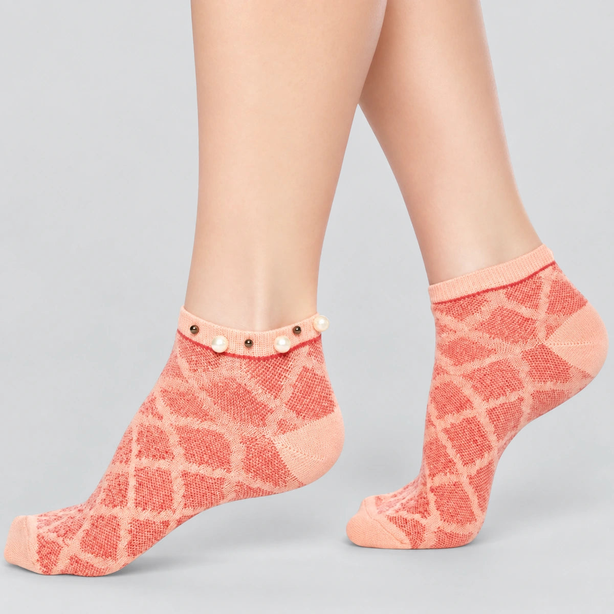 A woman wearing orange checked ankle socks finished with pearls around the cuff