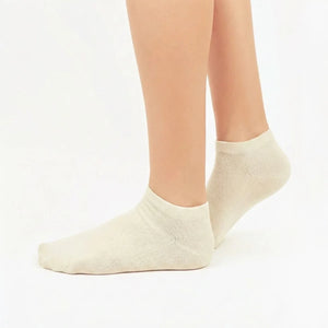 Soft beige bamboo ankle socks modeled on feet showing smooth texture and ribbed cuff