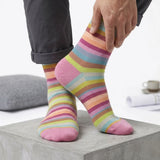 Person wearing colorful striped socks on a light background