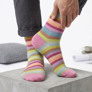 Person wearing colorful striped socks on a light background