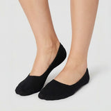 Woman wearing black no-show socks on light grey background