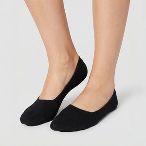 Woman wearing black no-show socks on light grey background