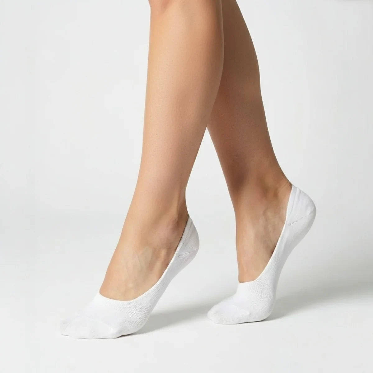 Woman wearing white no-show socks on light grey background