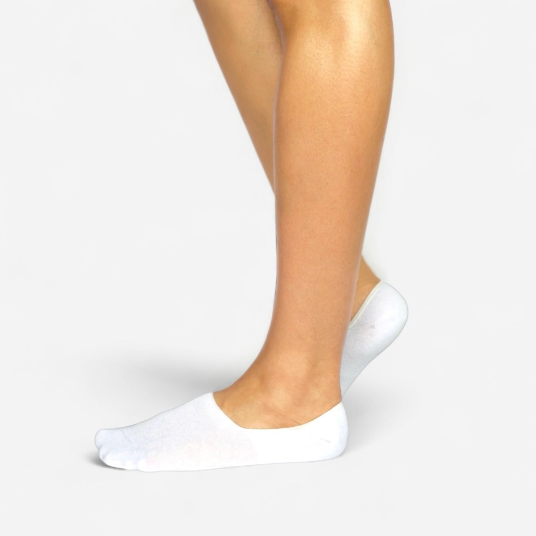 Person wearing seamless white bamboo no-show socks on a white background