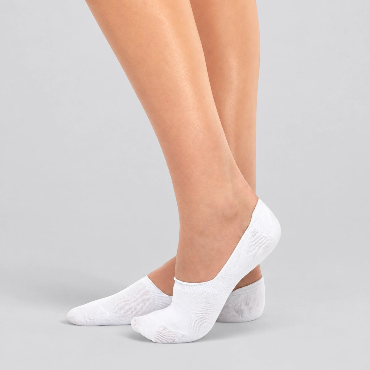 Person wearing seamless white bamboo no-show socks on a white background