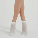 Photo of a person's legs wearing white, ventilated, non-slip, yoga and pilates socks