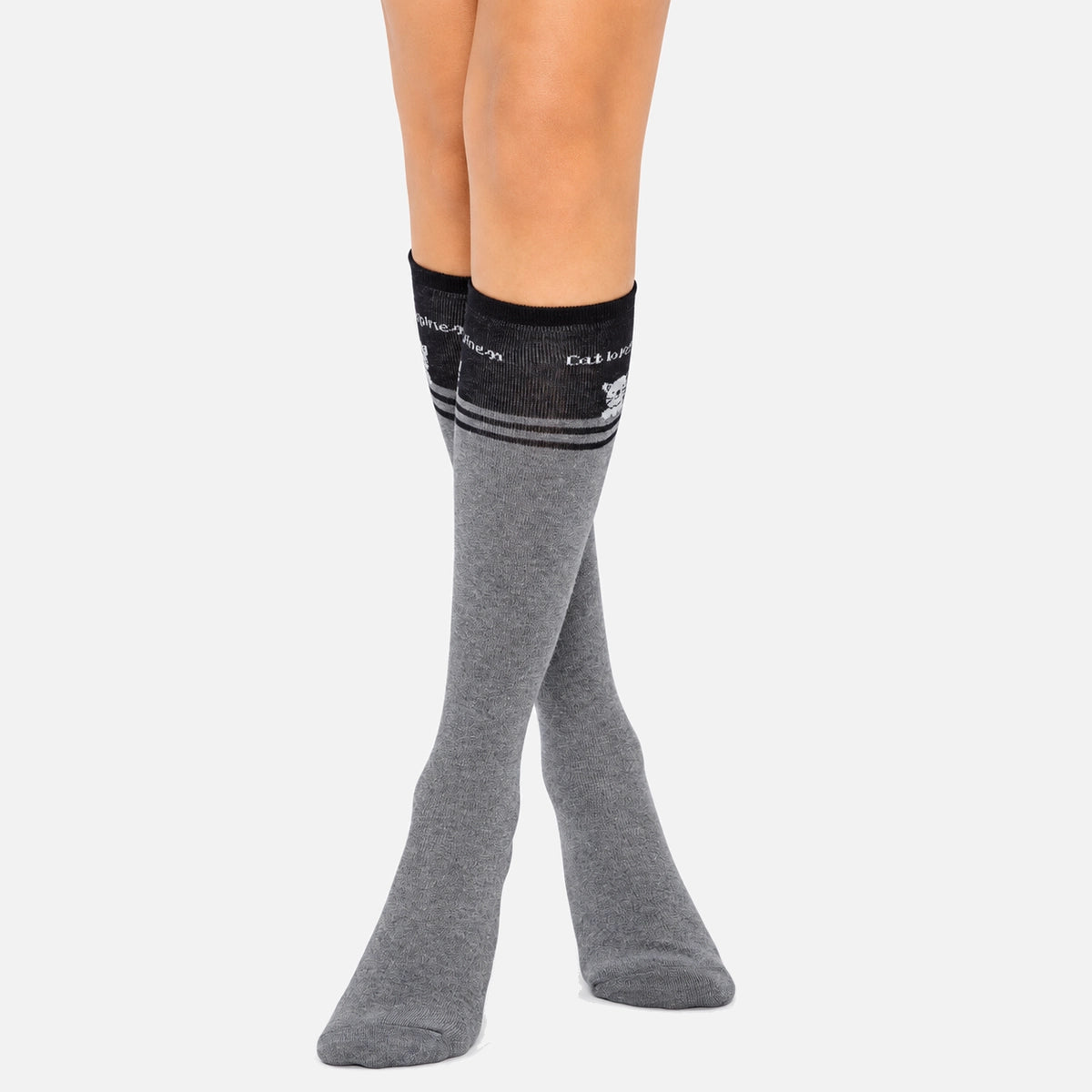A close-up of grey knee high socks with a playful cat design.