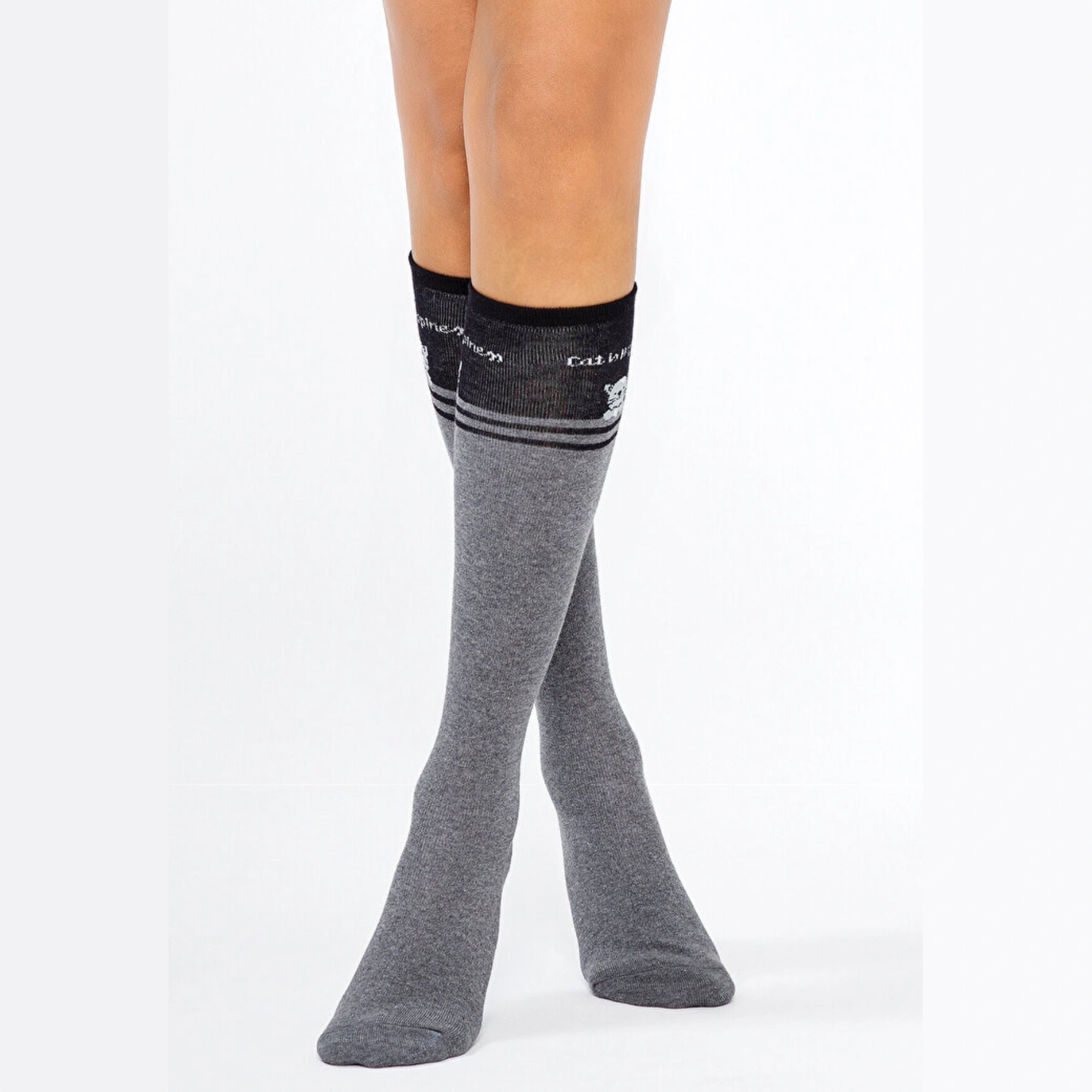 A close-up of grey knee high socks with a playful cat design.