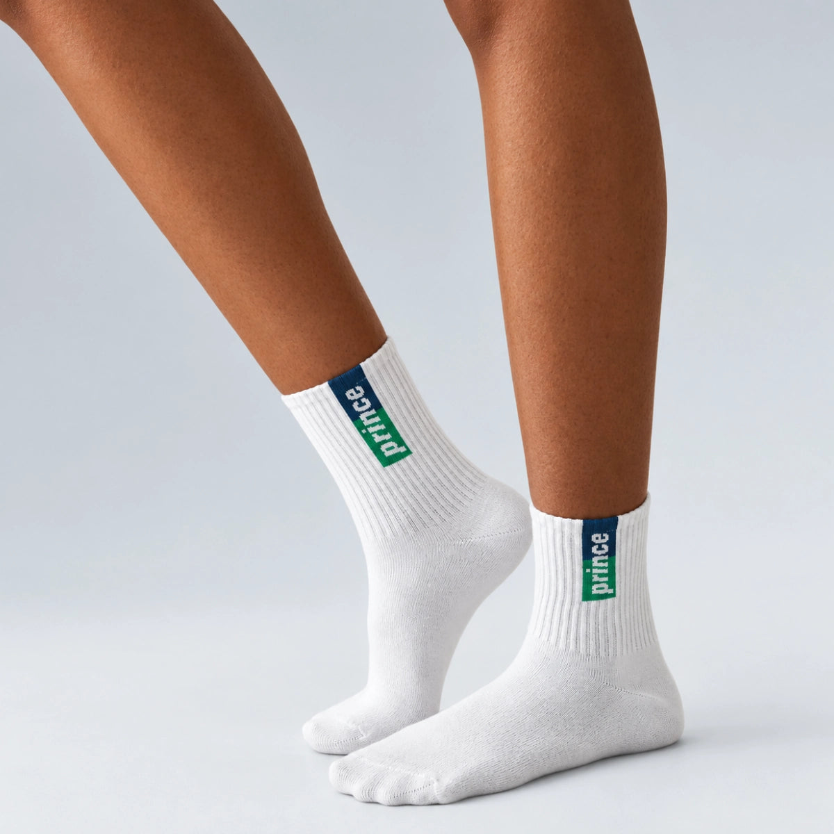 person wearing white tennis socks with blue and green Prince label