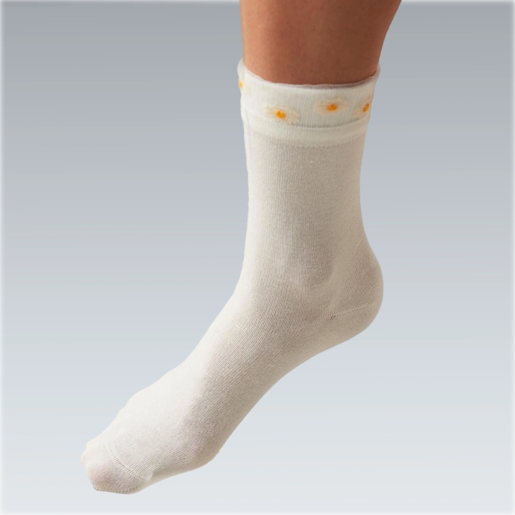 Close-up detail  ivory coloured quarter length socks with delicate yellow daisies on a sheer cuff