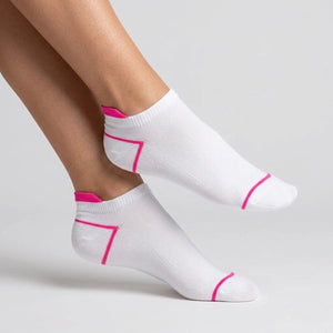 White ankle socks with pink accents worn by a person on a light grey background