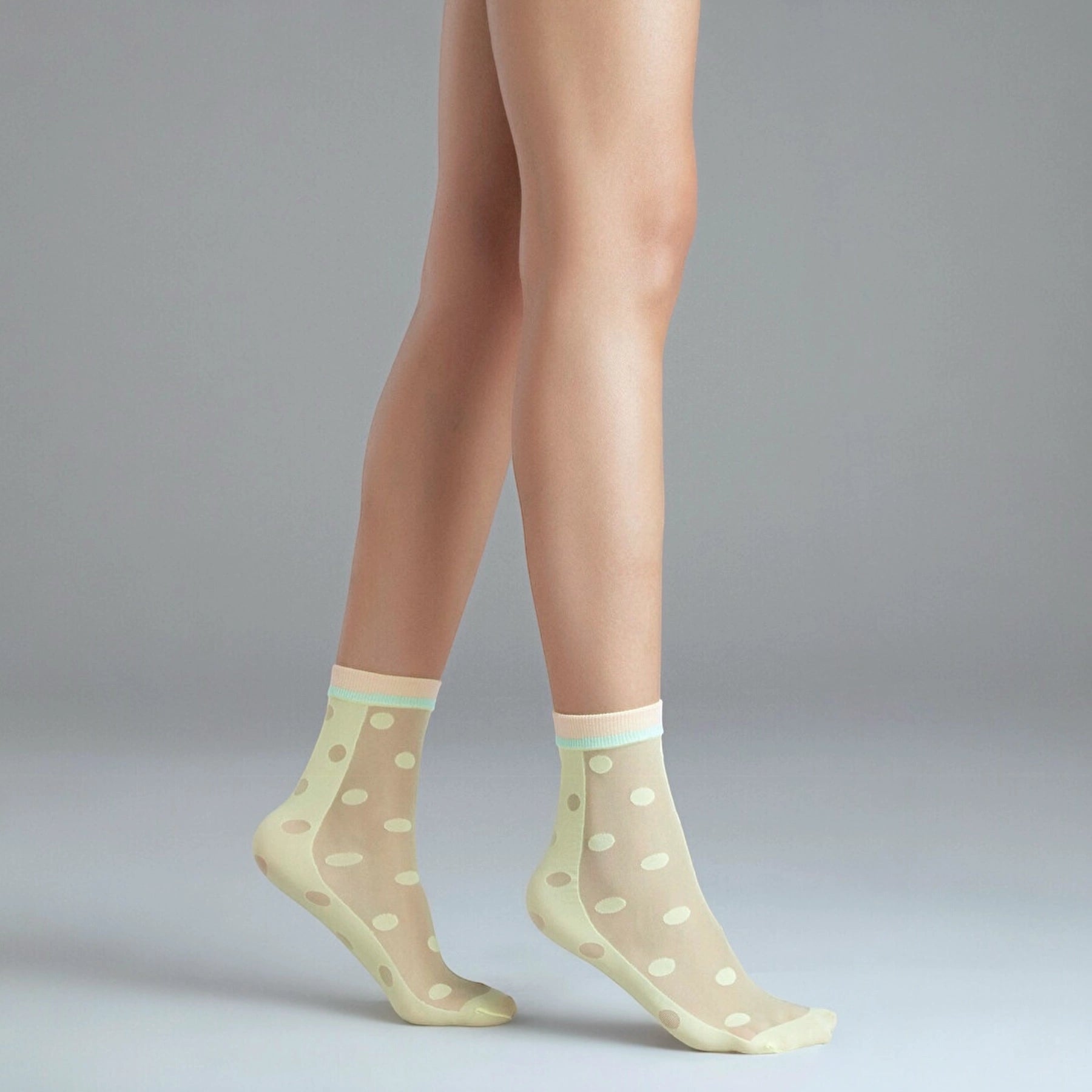 person wearing sheer yellow quarter length dotted socks with coloured cuff
