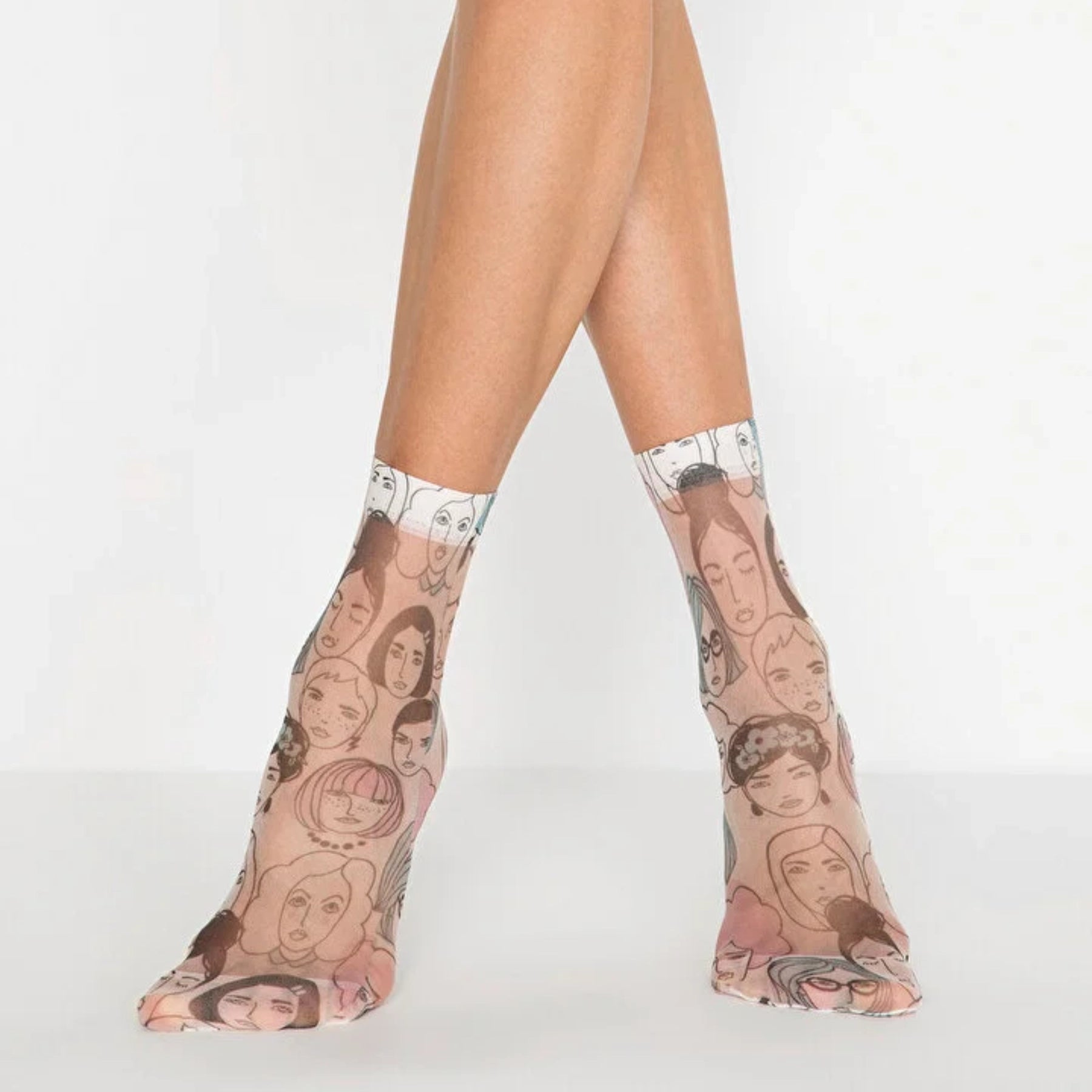 Sheer patterned ankle socks with face designs worn by a person on a white background