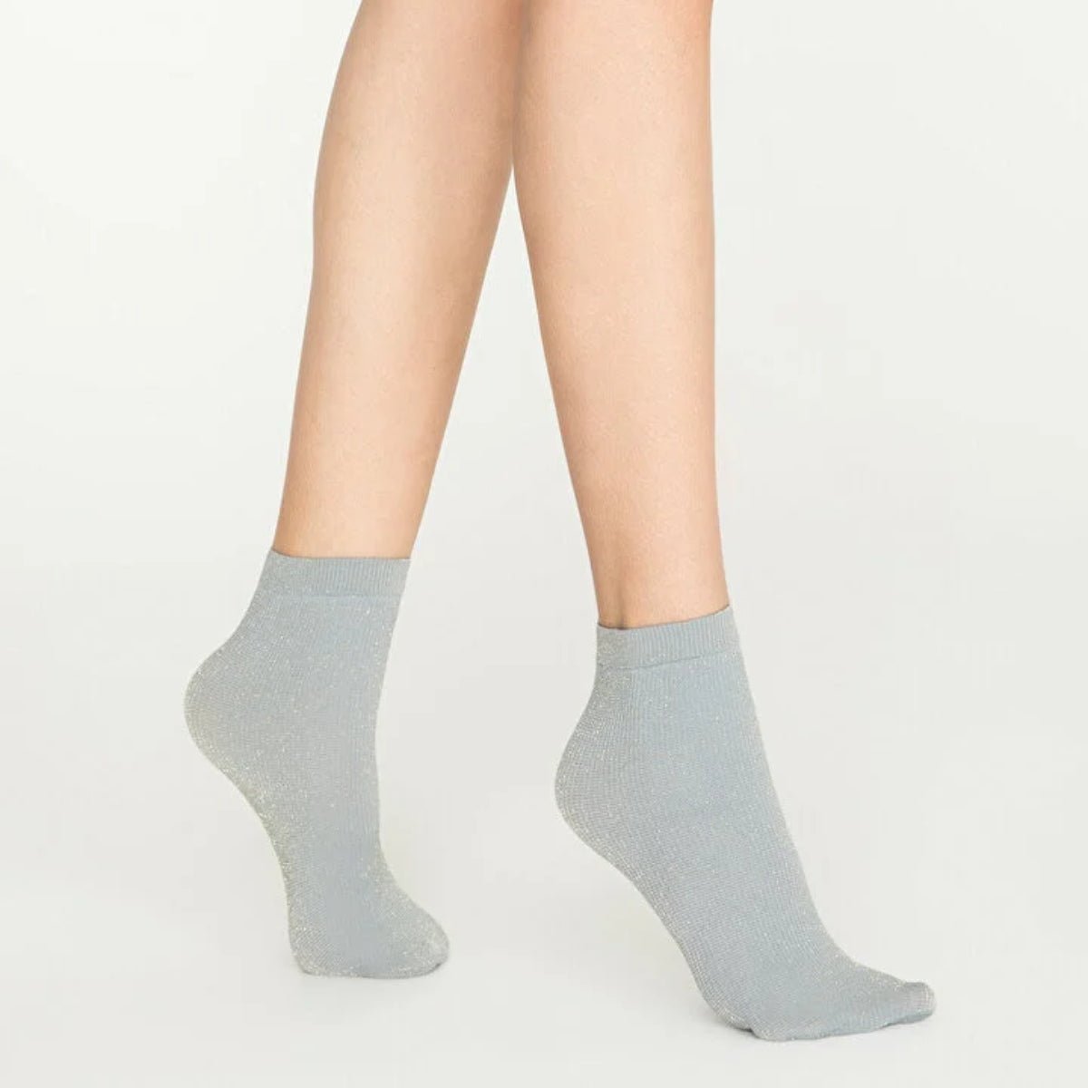 Woman wearing light grey, sparkly ankle sock