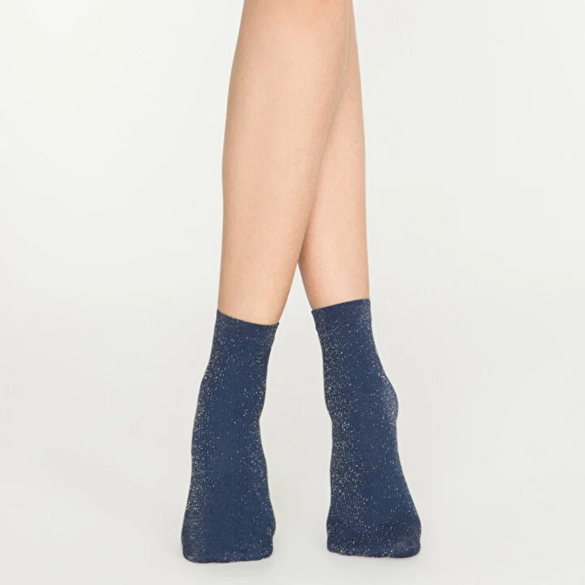 Woman wearing navy and gold, sparkly ankle sock