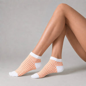 Person wearing white and apricot ankle socks against a light background