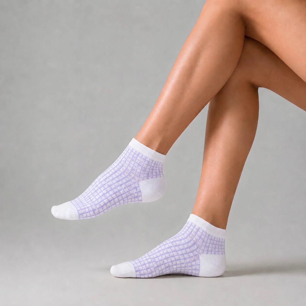 Person wearing white and lilac ankle socks against a light background