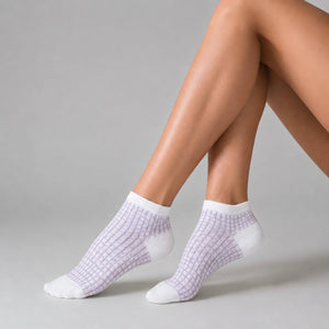 Person wearing white and lilac ankle socks against a light background