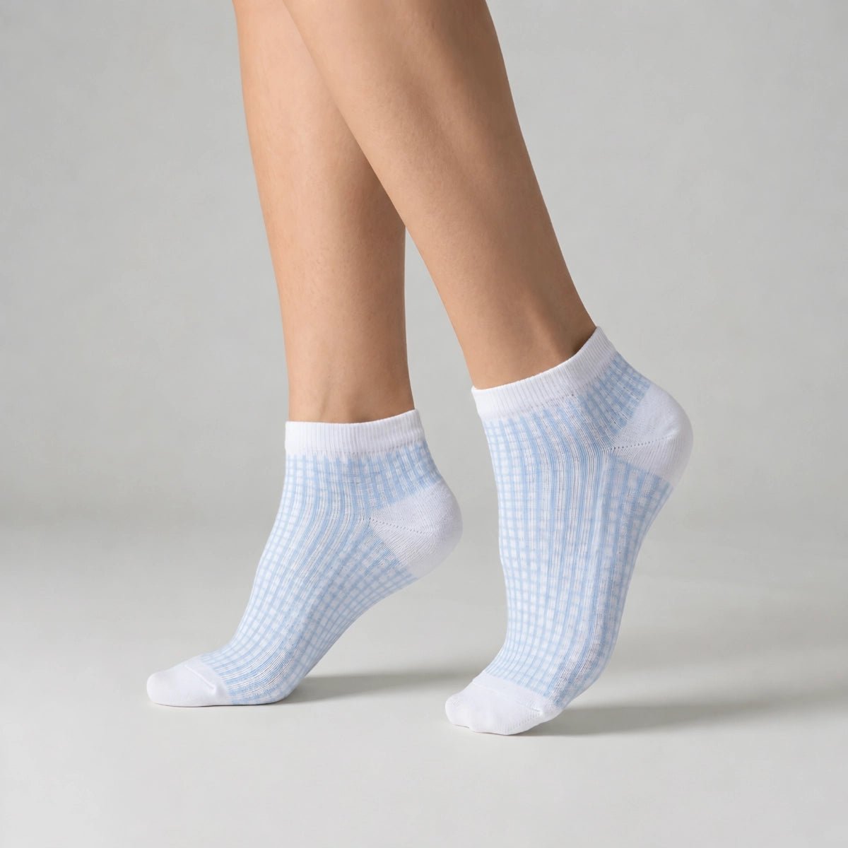 Person wearing white and blue ankle socks against a light background