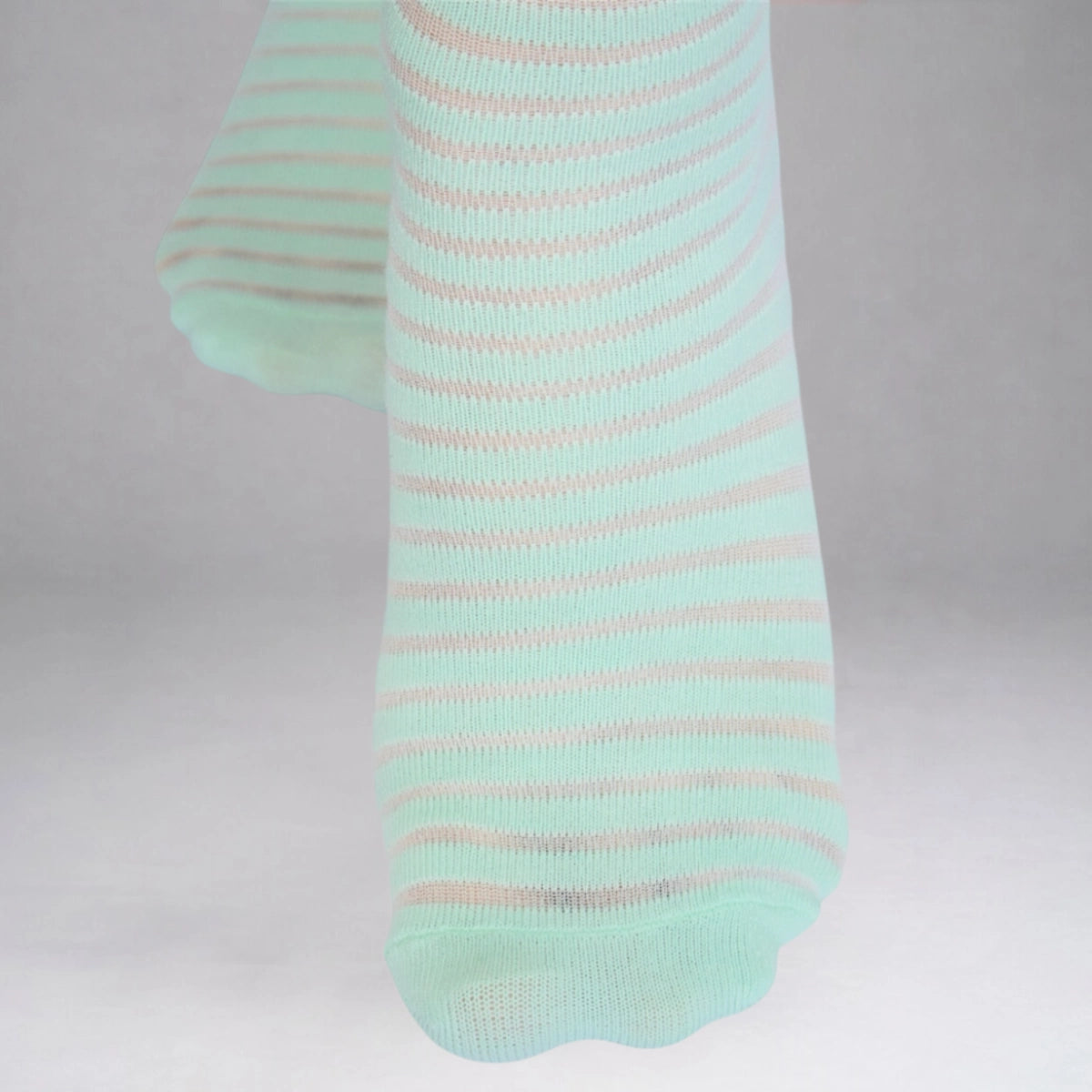 Mint socks with thin sheer stripes on a grey background