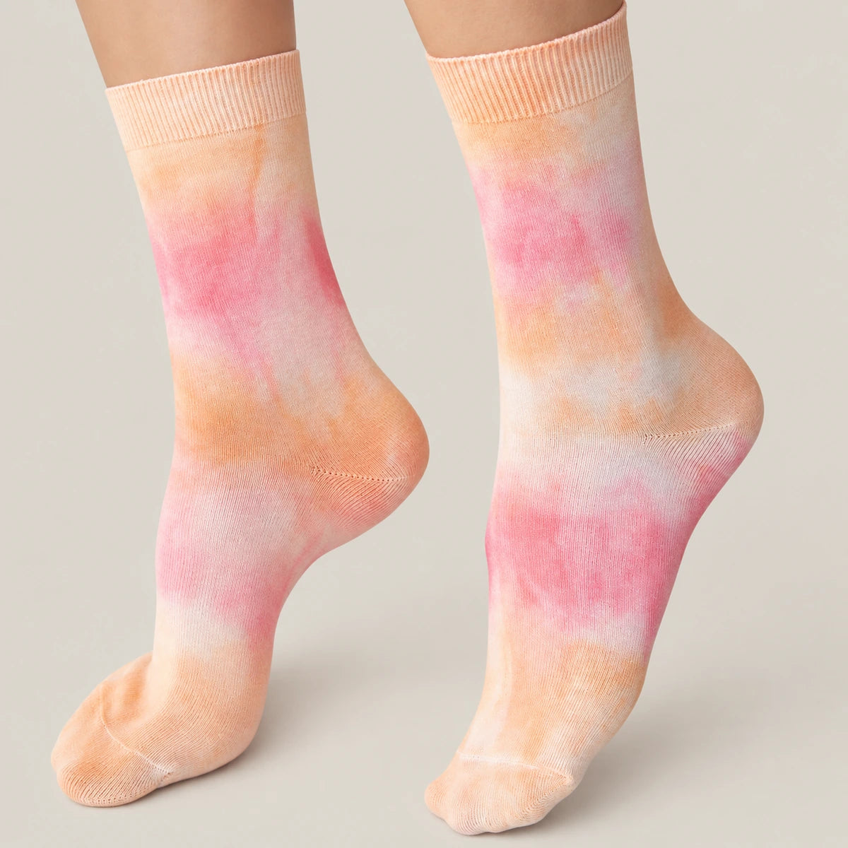 Person wearing washed orange and pink crew socks