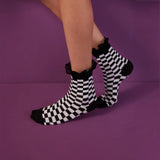 Woman wearing black and white checked sock with a black lace frilled cuff