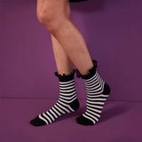 Woman wearing black and white striped sock with a black lace frilled cuff