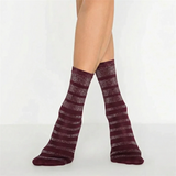 person wearing burgundy and gold striped crew socks on a light background