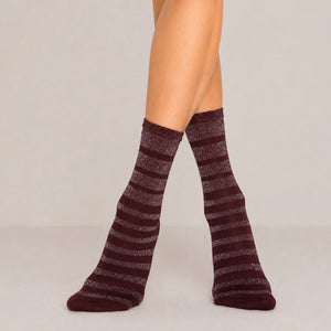 Burgundy glitter stripe women’s crew socks with metallic shimmer detail, styled standing against a soft neutral background