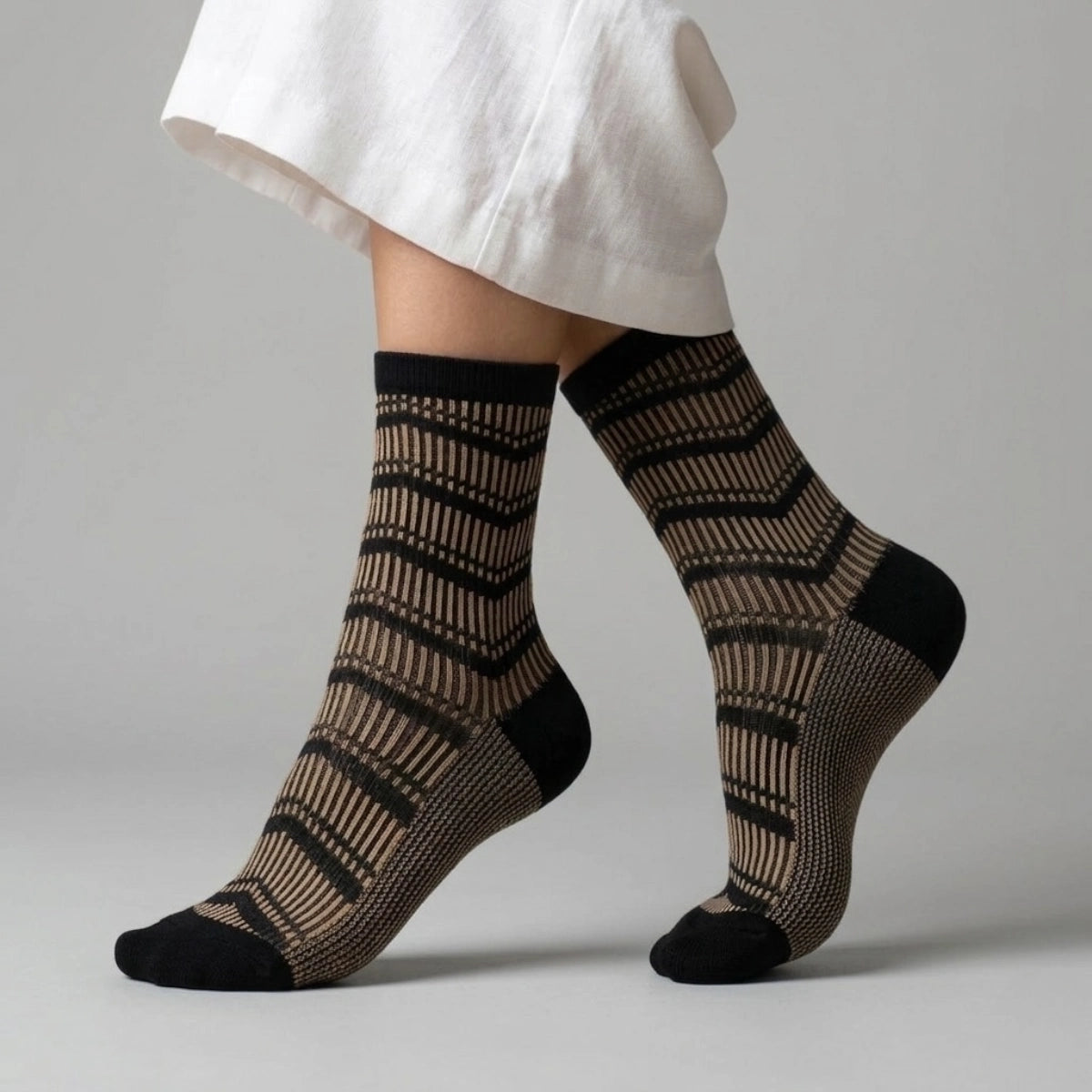 Person wearing black and gold striped socks against a light background