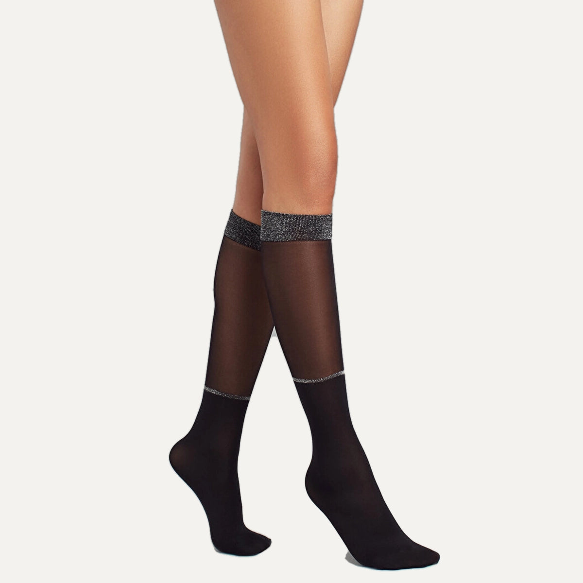 person wearing sheer black knee high socks with silver sparkly detail