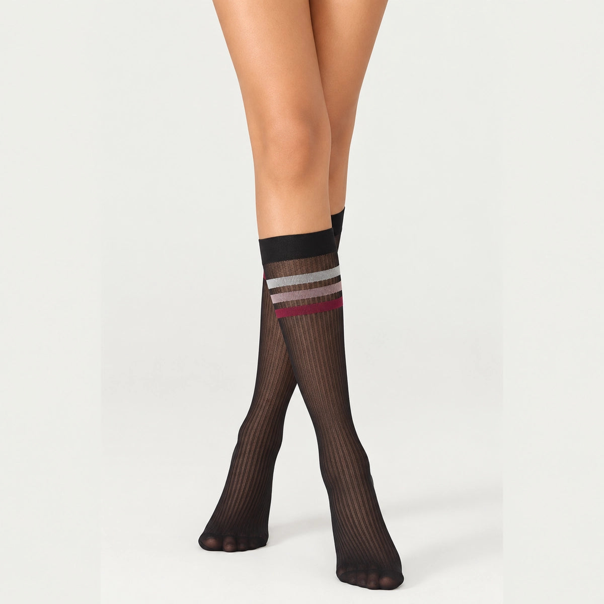 person wearing sheer black knee high socks with multicoloured striped cuff