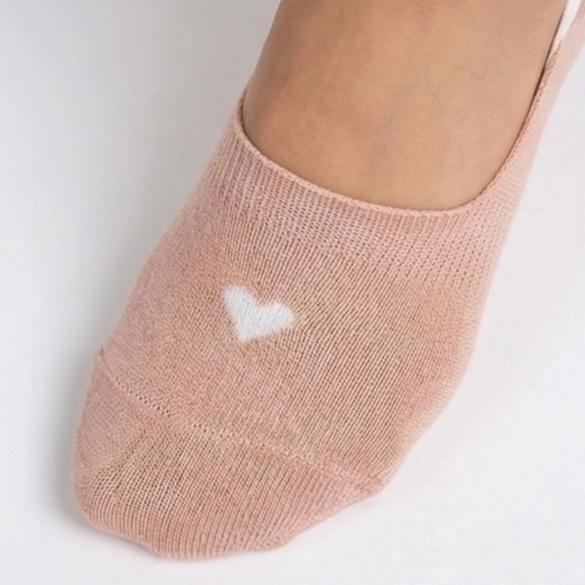 Beige no-show sock with a cream heart design on a light grey background