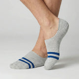 Grey no-show socks with blue stripes worn by a person on a light background