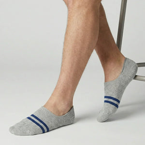 Grey no-show socks with blue stripes worn by a person on a light background