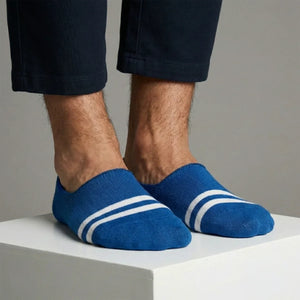 Blue no-show socks with white stripes worn by a person on a neutral background
