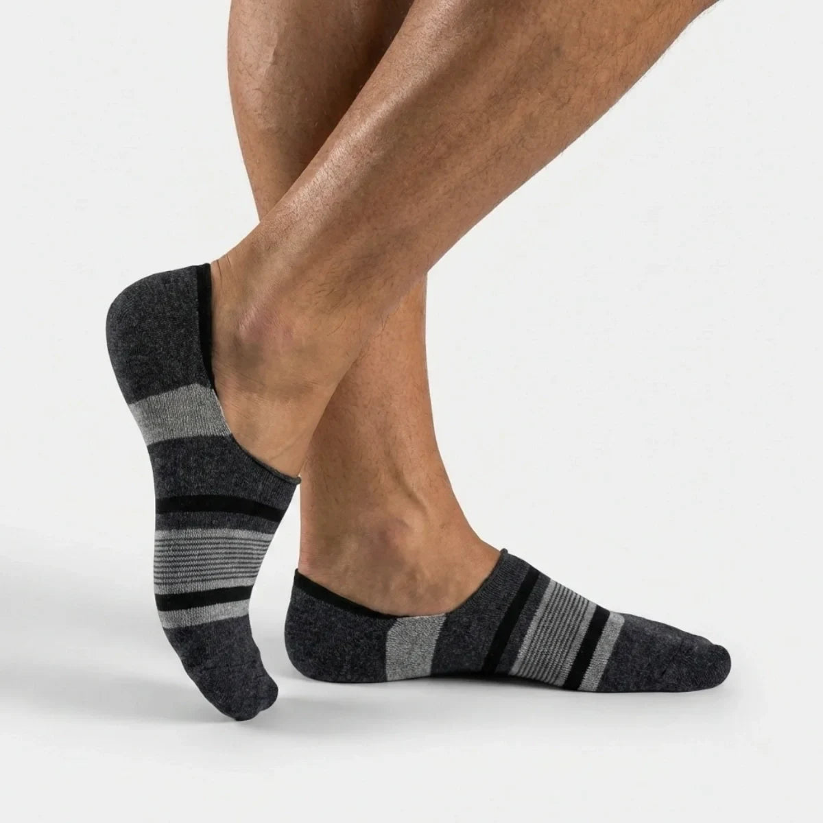 Grey striped no-show socks worn by a person on a white background