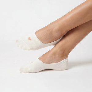 Person wearing a cream no-show socks with a beige heart design on a light grey background