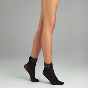 person wearing black quarter length socks with sequined cuff