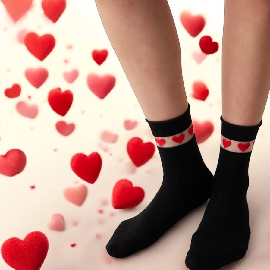 Woman's feet showing quarter length black socks with sheer cuff adorned with red love hearts, with floating love hearts around her