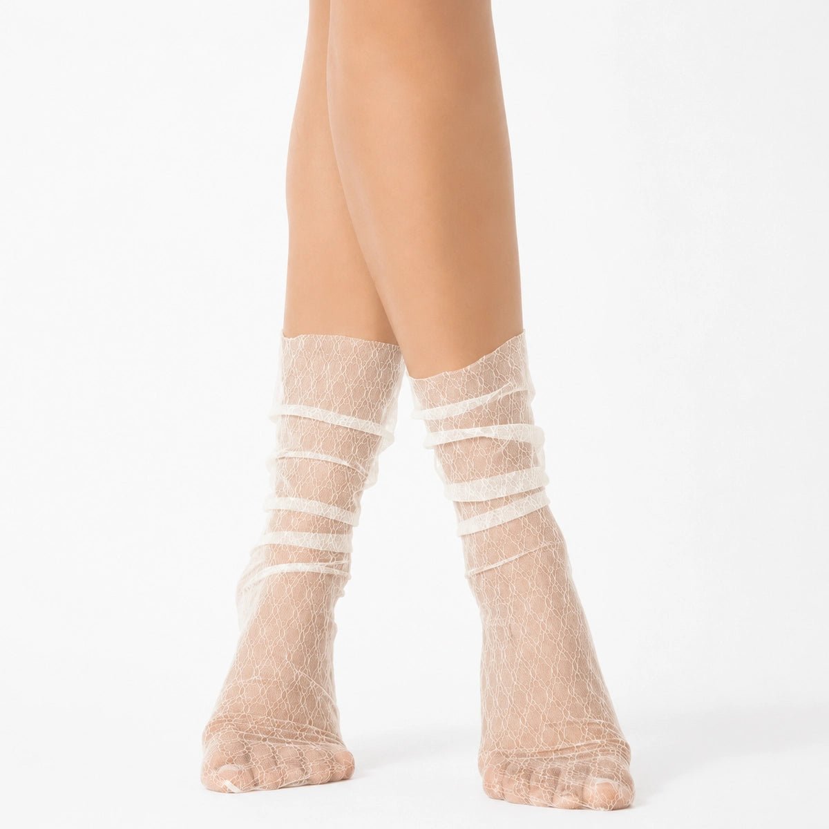 Ivory sheer designer ankle socks with delicate lace pattern styled on a female model against a light background