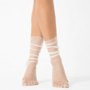 Ivory sheer designer ankle socks with delicate lace pattern styled on a female model against a light background