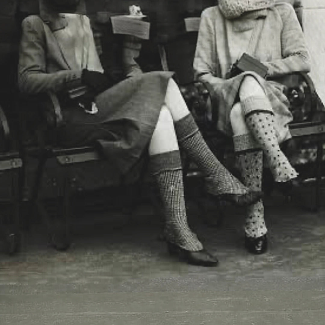 Vintage photo of two ladies sitting on a park bench wearing traditional socks