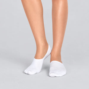 Person wearing seamless white bamboo no-show socks on a white background