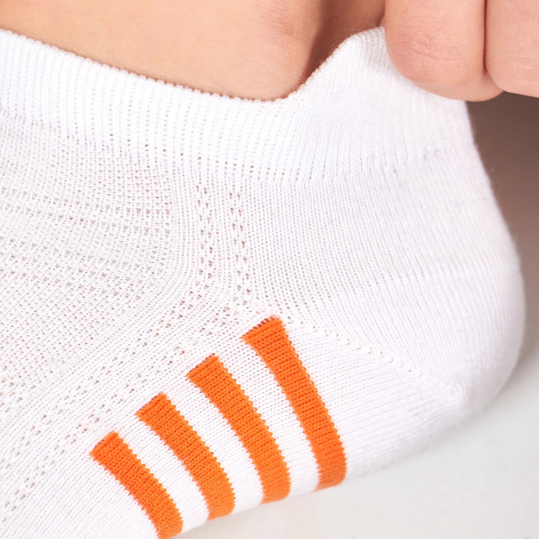 close-up detail of white bamboo athletic socks with orange and blue stripe