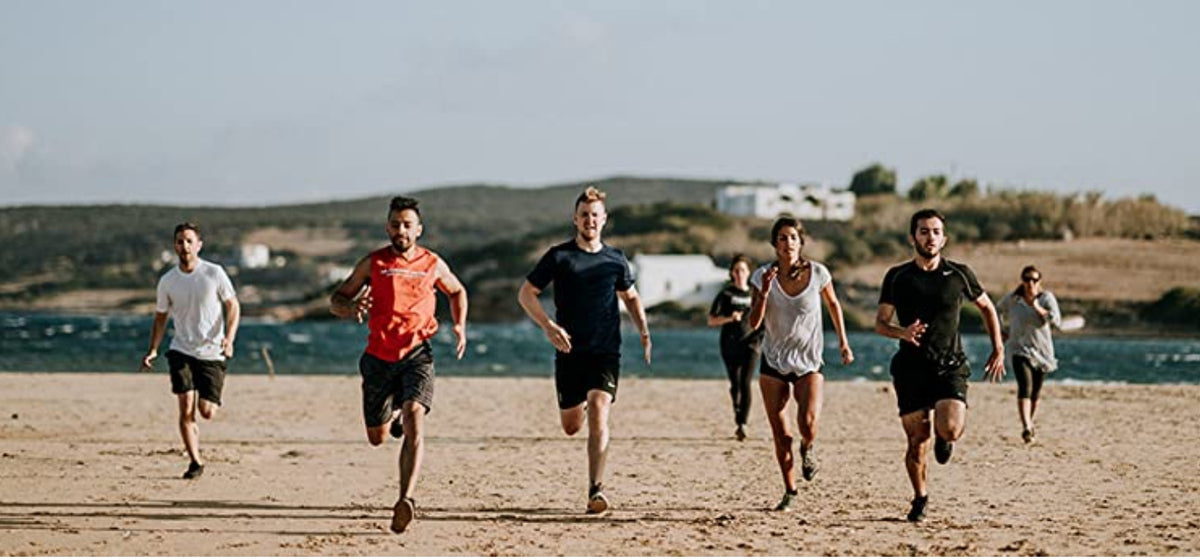 A group of individuals wearing fashion socks runs along the beach, enjoying the sun and the ocean breeze.