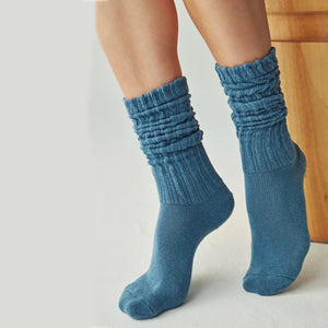 A person's legs wearing blue ribbed leg-warmer socks