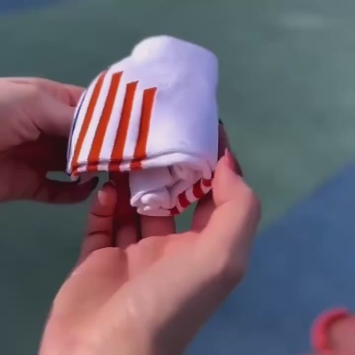 Video of person demonstrating white and orange sneaker socks