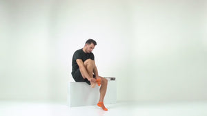 Video of man wearing orange athletic sock for running and golf with heel tab