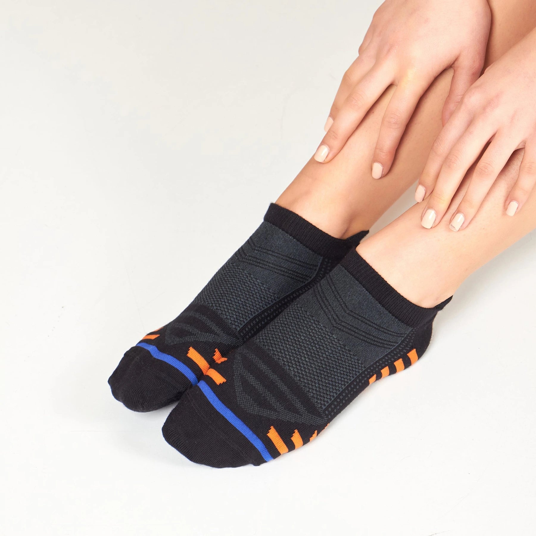 woman wearing black bamboo athletic socks with orange and blue stripe